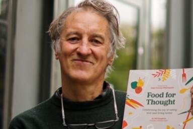 Phil Haughton holding his book, Food for Thought