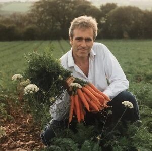 Patrick Holden, SFT CEO, holds up a handful of carrots grown on his farm