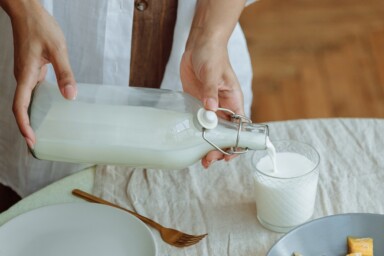 Someone pouring milk into a glass