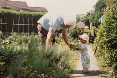 Julie's grandfather showing her daughter, Megan, herbs and vegetables in the garden.