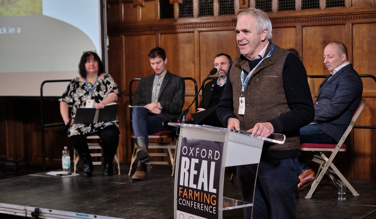 SFT CEO, Patrick Holden, standing at a podium to introduce our Grazing Livestock session at the Oxford Real Farming Conference 2024