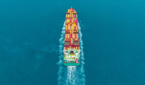 Birds eye view of a cargo ship sailing through the ocean. Image by Suphanat Khumsap via Getty Images.