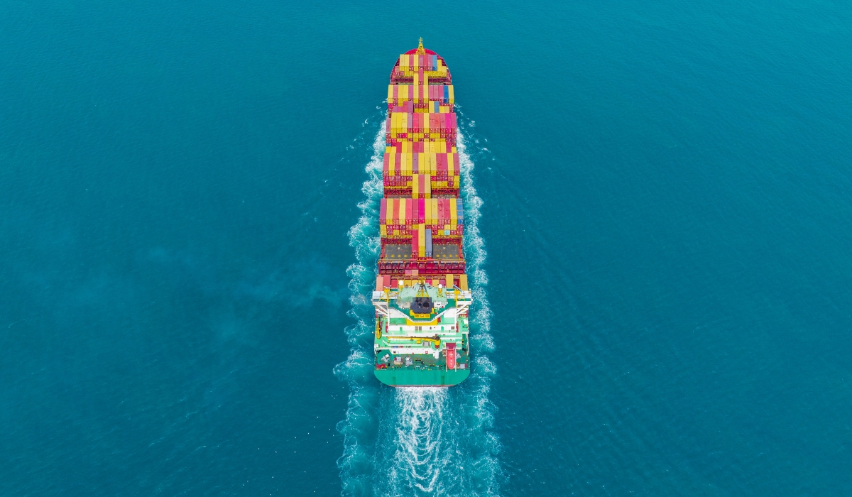 Birds eye view of a cargo ship sailing through the ocean. Image by Suphanat Khumsap via Getty Images.
